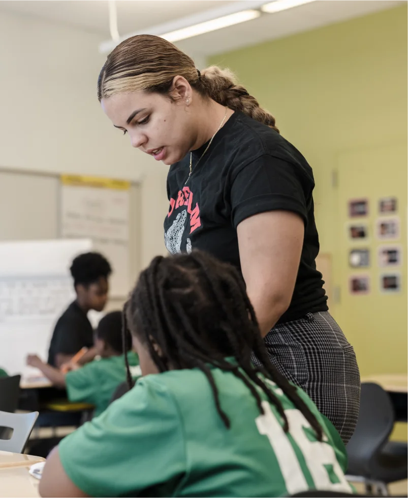 jenia standing at a student's desk